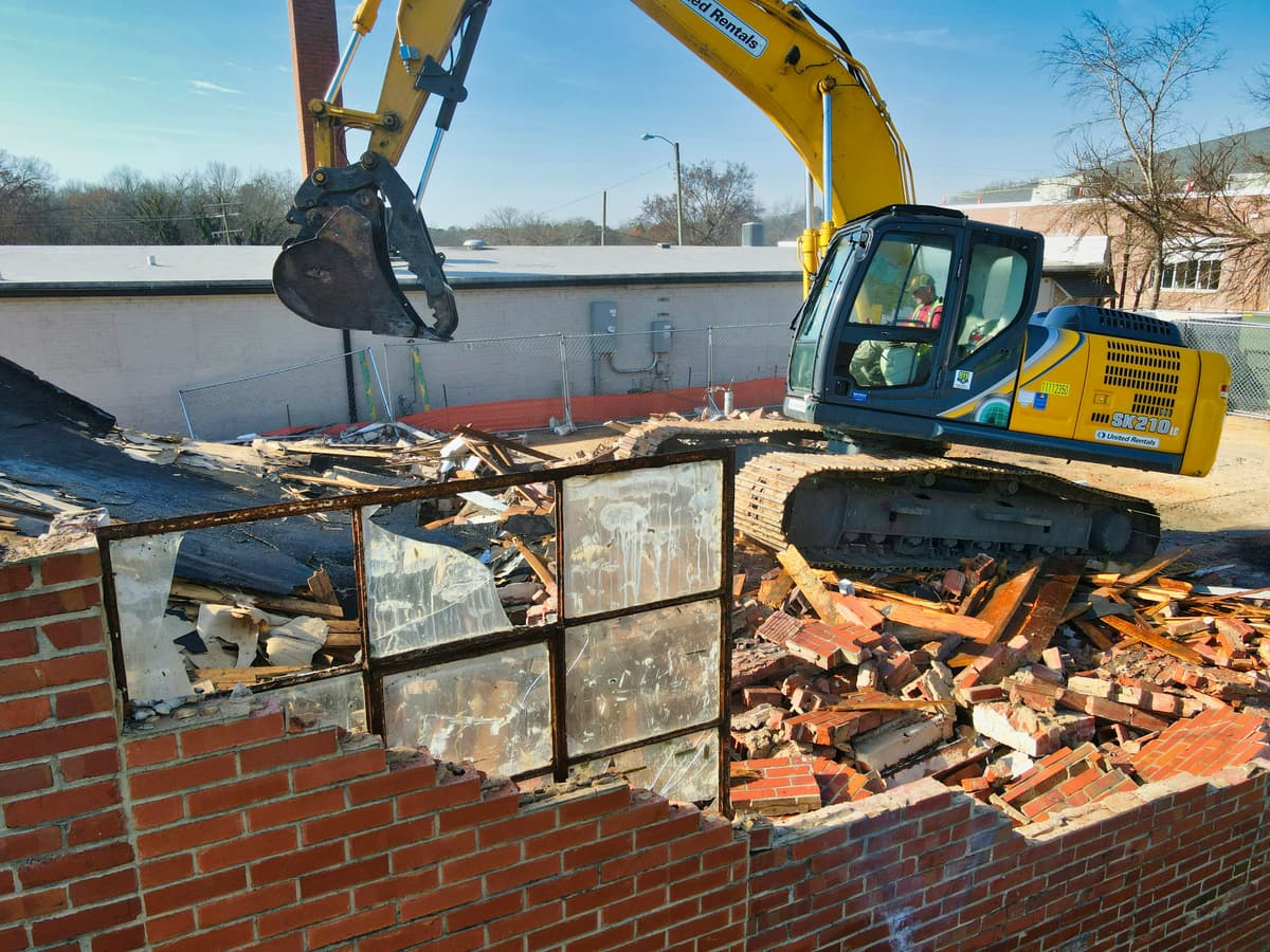 Excavator demolishing a brick structure
